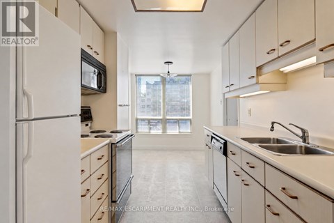 A kitchen with white cabinets and a black microwave.
