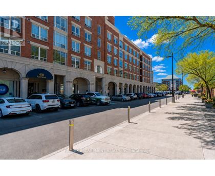 A street view of a building with cars parked in front.