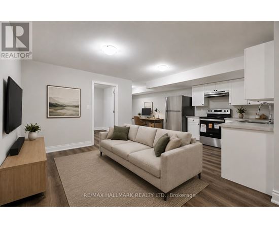 A modern living room with a couch, a television, and a kitchen area in the background.