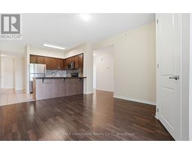 A spacious room with wooden flooring and white walls.