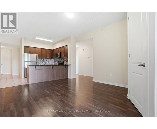 A spacious room with wooden flooring and white walls.