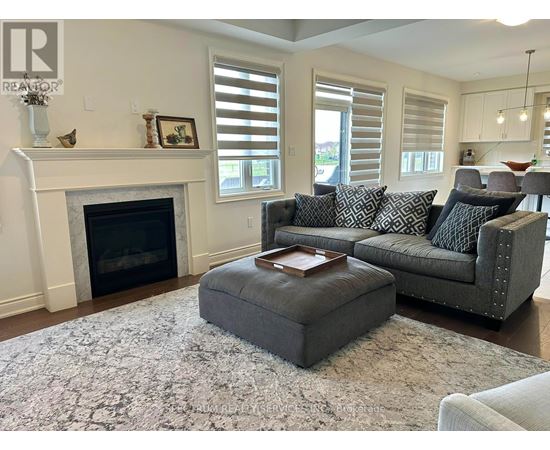 A living room with a grey couch and a fireplace.