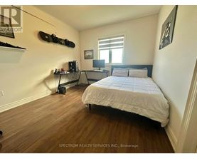 A bedroom with a bed, desk, and a skateboard mounted on the wall.