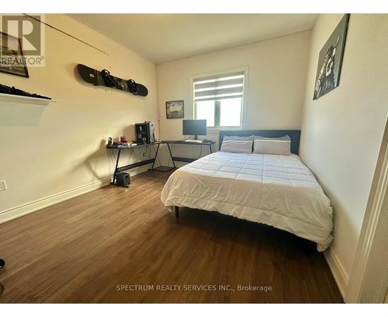 A bedroom with a bed, desk, and a skateboard mounted on the wall.