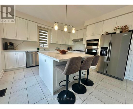A kitchen with white cabinets and a marble countertop.