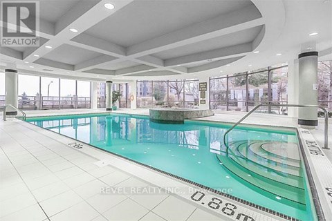 A large indoor swimming pool with a glass bottom.