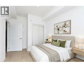 A bedroom with a bed, nightstand, and lamp.
