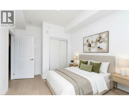 A bedroom with a bed, nightstand, and lamp.