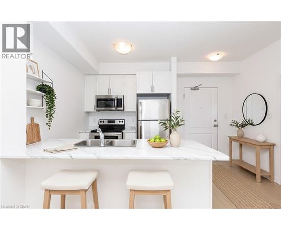 A modern kitchen with white cabinets and a marble countertop.