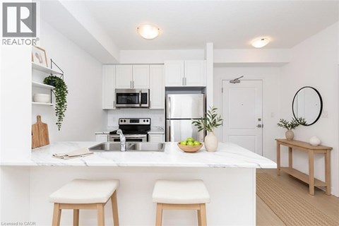 A modern kitchen with white cabinets and a marble countertop.