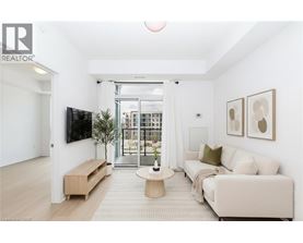 A living room with a white couch, a wooden coffee table, and a flat-screen TV mounted on the wall.