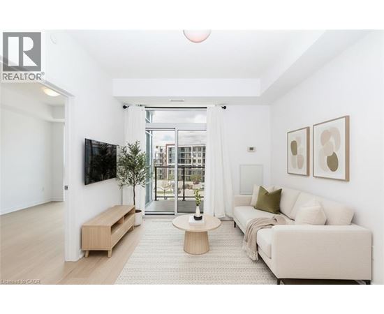 A living room with a white couch, a wooden coffee table, and a flat-screen TV mounted on the wall.