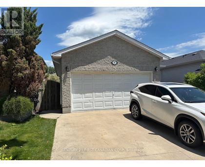 A white car is parked in front of a garage.