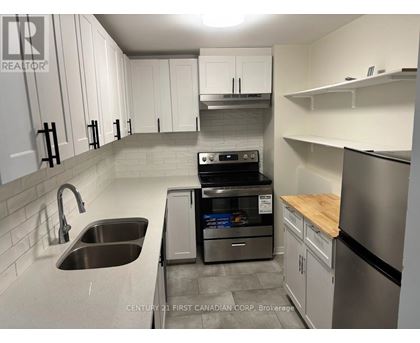 A kitchen with a stainless steel dishwasher and refrigerator.