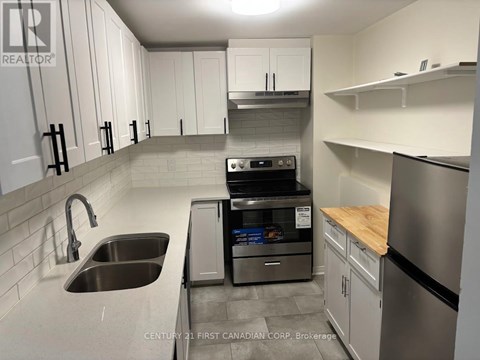 A kitchen with a stainless steel dishwasher and refrigerator.