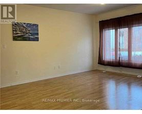 A room with wooden flooring and a painting on the wall.