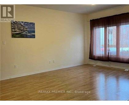 A room with wooden flooring and a painting on the wall.