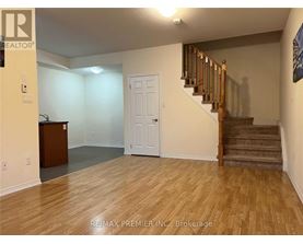 A room with a staircase and a white door.