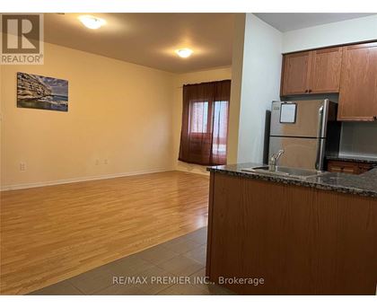 A kitchen area with wooden cabinets and a refrigerator.