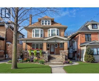 A large house with a front yard and a tree.