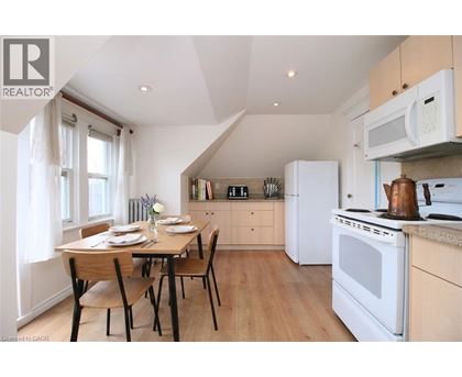 A kitchen with a table set for two with a window behind it.