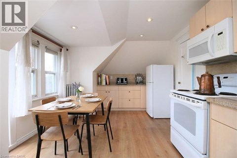 A kitchen with a table set for two with a window behind it.