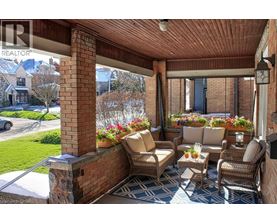 A patio with a couch, chairs, and a table with flowers on it.