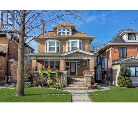 A large house with a front yard and a tree.