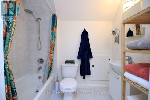A small bathroom with a toilet, sink, and shower.