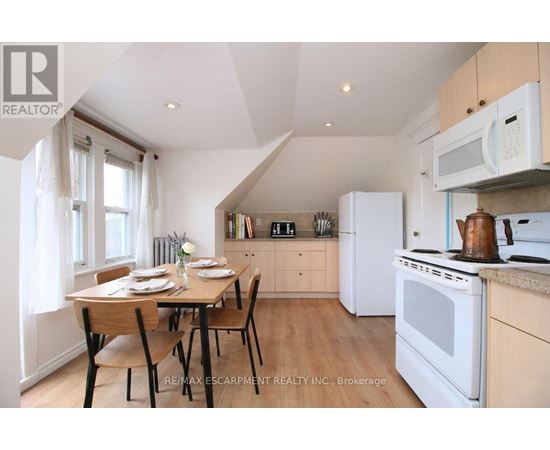 A kitchen with a table set for two with a window behind it.