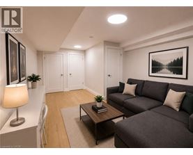 A living room with a grey couch, a coffee table, and a lamp.
