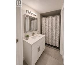 A bathroom with a sink, mirror, and shower curtain.