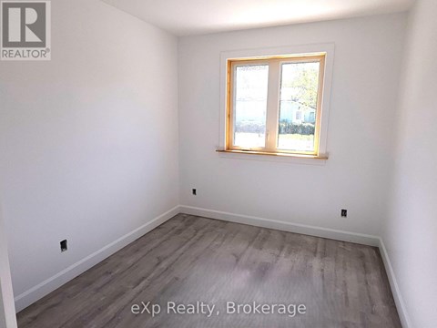 A room with a window and wooden flooring.