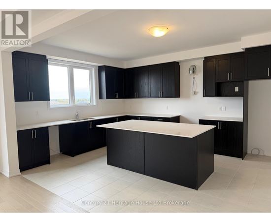 A kitchen with black cabinets and a white island.
