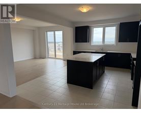 A kitchen with black cabinets and a large island in the middle.