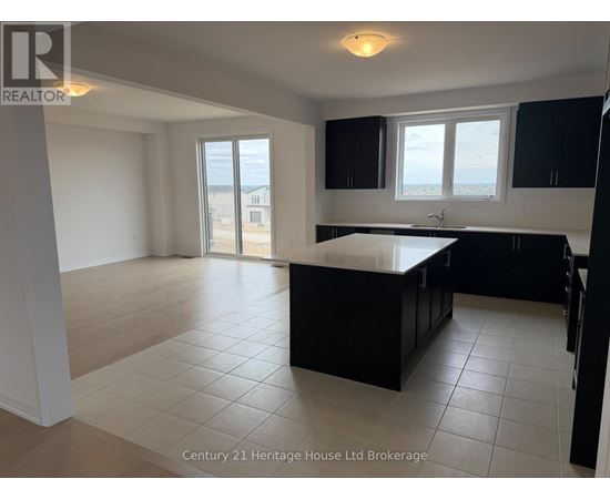 A kitchen with black cabinets and a large island in the middle.