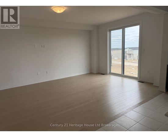 Empty room with a sliding glass door leading to a construction site.
