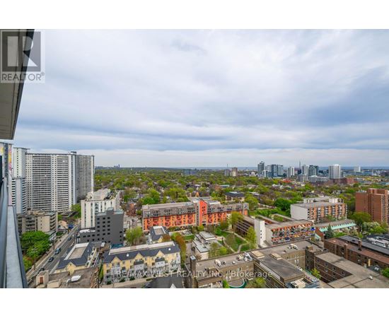 A cityscape with buildings of various heights and a cloudy sky.