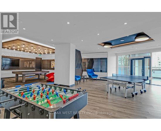 A foosball table is in the middle of a room with a pool table and a ping pong table.