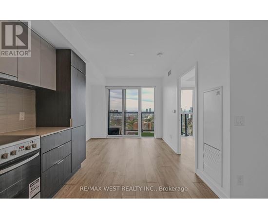 A modern kitchen with dark wood cabinets and a stove top oven.