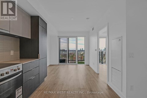 A modern kitchen with dark wood cabinets and a stove top oven.