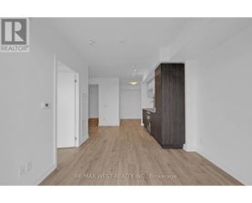 A spacious room with a wooden floor and white walls.