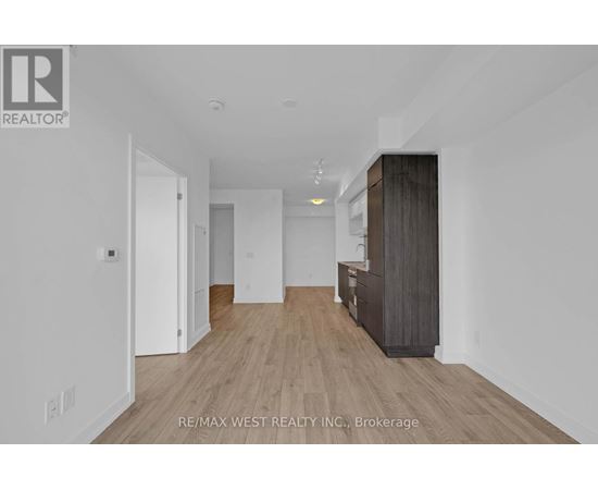 A spacious room with a wooden floor and white walls.