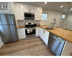A kitchen with a stainless steel refrigerator, oven, and microwave.
