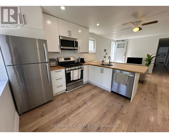 A kitchen with a stainless steel refrigerator, oven, and microwave.