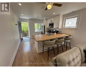 A kitchen with a wooden countertop and a stainless steel sink.