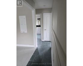 A hallway with a white door and a white wall.