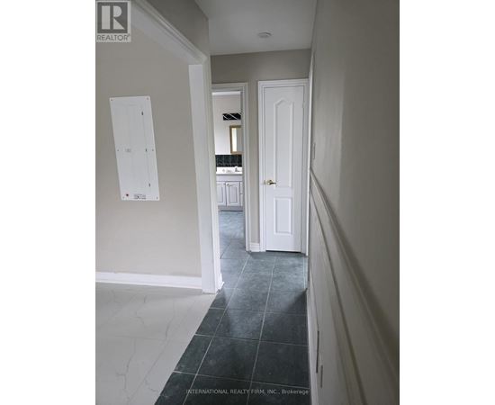 A hallway with a white door and a white wall.