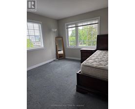 A bedroom with a bed, dresser, and window.