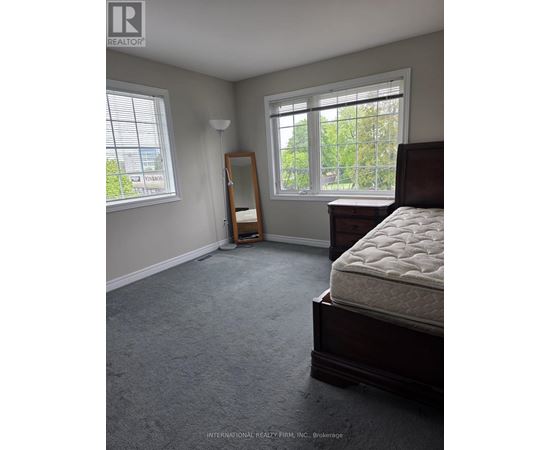 A bedroom with a bed, dresser, and window.